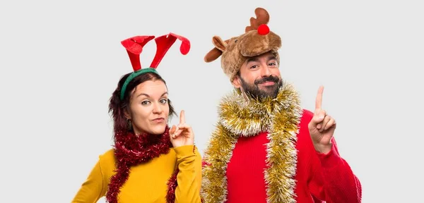 Paar Verkleidet Für Die Weihnachtsfeiertage Zeigt Und Hebt Einen Finger — Stockfoto