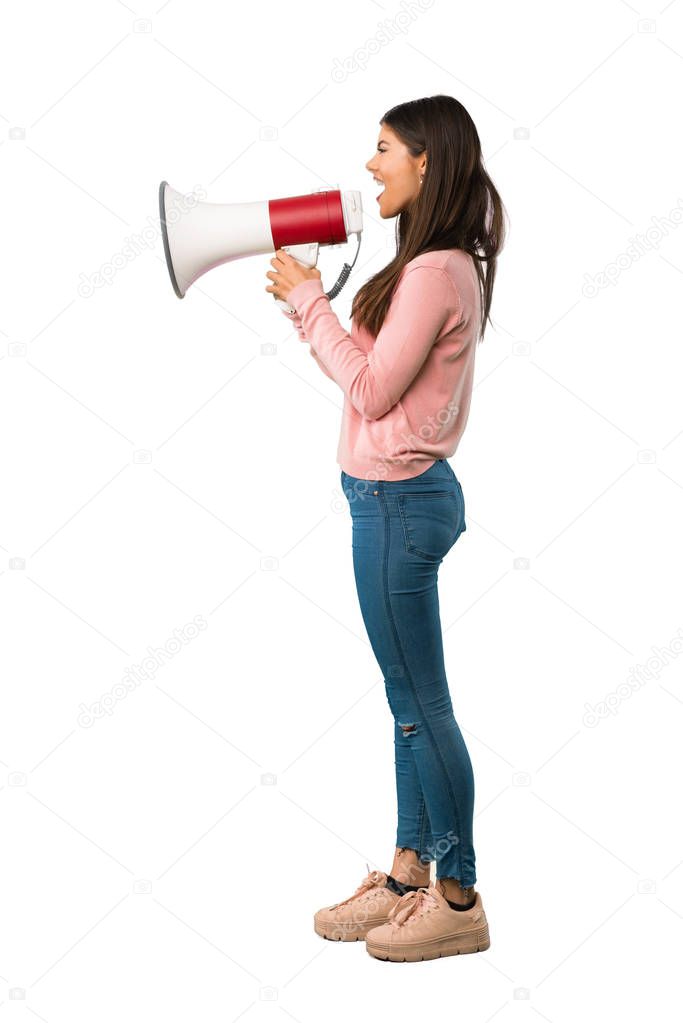 A full-length shot of a Teenager girl with pink shirt shouting through a megaphone to announce something in lateral position