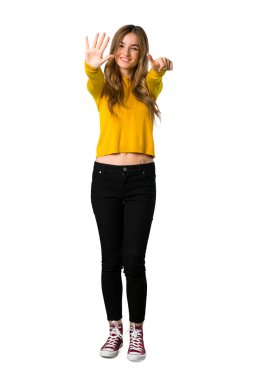 Bir genç kızın sarı kazaklı altı ile izole beyaz arka plan üzerinde parmak sayma tam uzunlukta bir atış