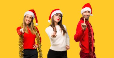 Gösterilen ve sarı zemin üzerine en iyi işareti parmak kaldırma Noel tatili için bir grup kişiye sarışın kadın giyinmiş