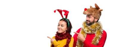 Çift yan ürün yalıtılmış arka plan üzerinde sunmak için bir parmak ile işaret Noel tatili için giyinmiş