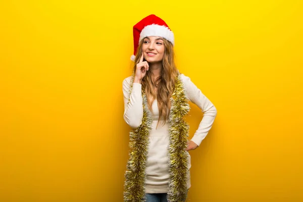 Menina Celebrando Feriados Natal Fundo Amarelo Pensando Uma Ideia Enquanto — Fotografia de Stock