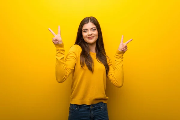 Κορίτσι Έφηβος Ζωντανό Κίτρινο Φόντο Χαμογελώντας Και Δείχνοντας Σήμα Της — Φωτογραφία Αρχείου