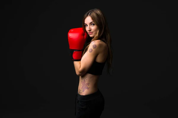 Sport woman with boxing gloves on dark background