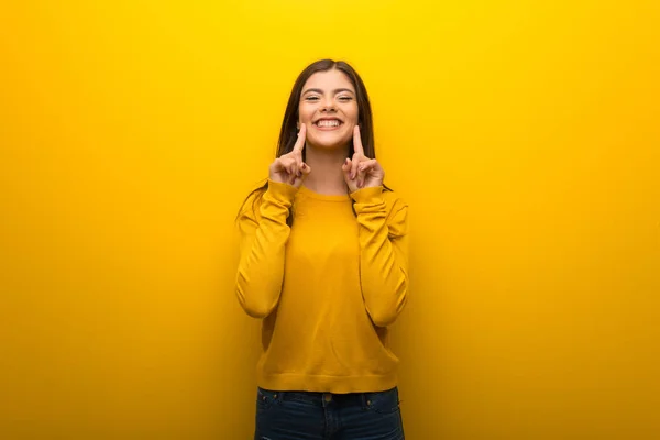 Chica Adolescente Sobre Fondo Amarillo Vibrante Sonriendo Con Una Expresión —  Fotos de Stock
