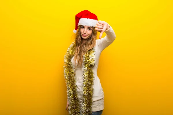Dívka Slaví Vánoční Svátky Žlutém Pozadí Ukazuje Palec Dolů Cedulka — Stock fotografie
