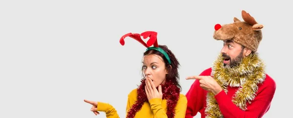 Paar Verkleidet Für Die Weihnachtsfeiertage Zeigt Mit Dem Finger Zur — Stockfoto