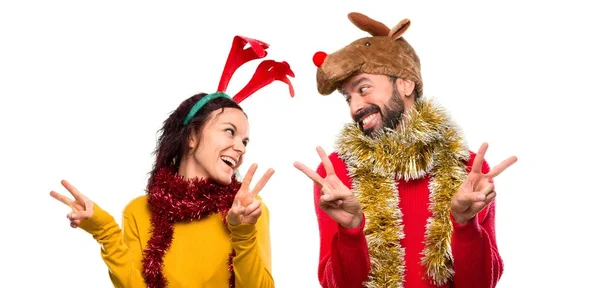 Casal Vestido Para Feriados Natal Sorrindo Mostrando Sinal Vitória Com — Fotografia de Stock