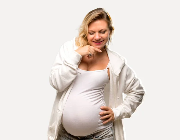 Kobieta Ciąży Blondynka Białą Bluzę Stojąc Patrząc Dół Białym Tle — Zdjęcie stockowe