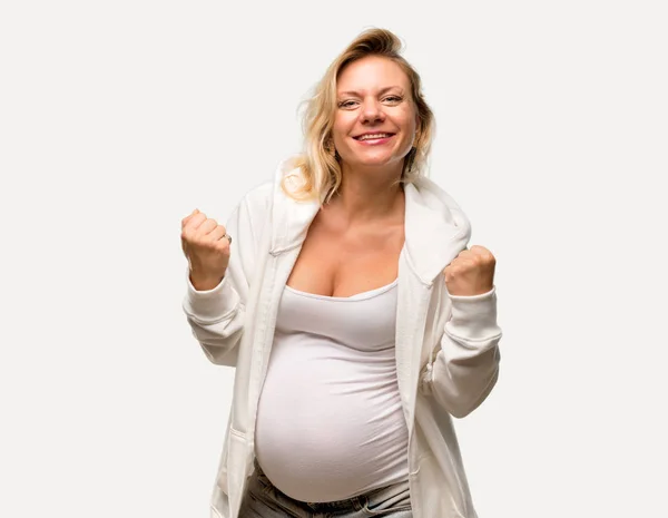 孤立した灰色の背景上の勝利を祝って白いトレーナーと金髪妊婦 — ストック写真