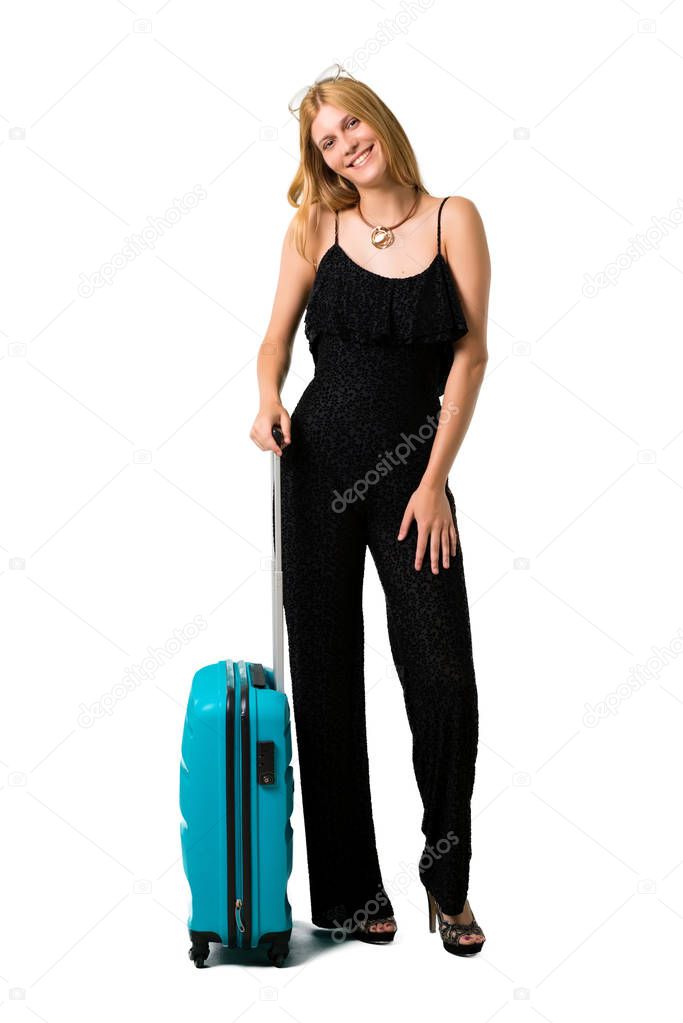 Blond girl traveling with her suitcase standing and thinking an idea while looking up on isolated white background