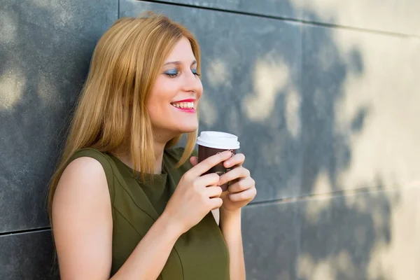 快乐漂亮的年轻少女拿着热咖啡在外卖纸杯在斯特雷特 — 图库照片
