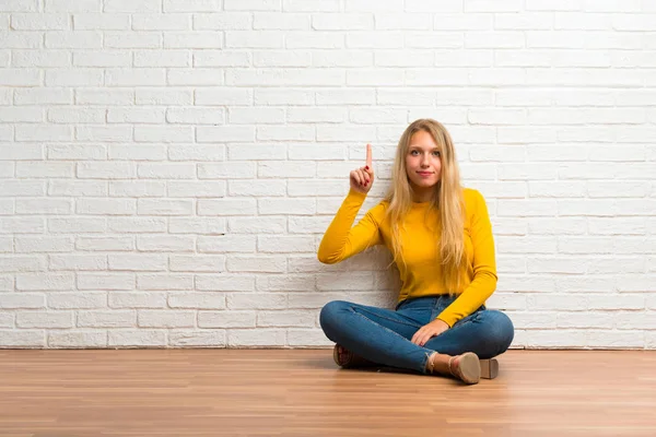 Jong Meisje Zittend Vloer Tonen Een Vinger Teken Van Beste — Stockfoto