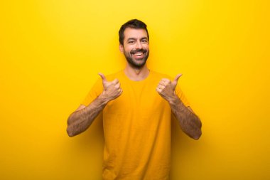 Adam her iki el ile jest Yaşasın vererek ve gülümseyen izole canlı sarı renk
