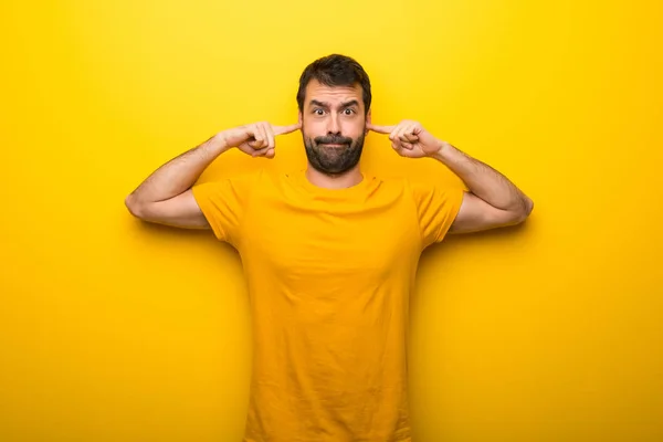 Muž Izolované Zářivé Žluté Barvy Zahrnující Obě Uši Rukama — Stock fotografie