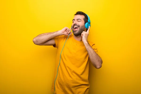 Άνθρωπος Απομονωμένες Δονούμενο Χρώμα Κίτρινο Ακούτε Μουσική Ακουστικά — Φωτογραφία Αρχείου