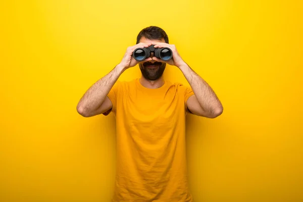 Hombre Color Amarillo Vibrante Aislado Buscando Algo Distancia Con Binoculares — Foto de Stock