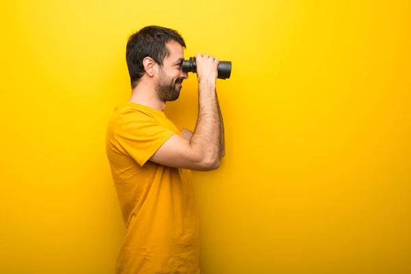 Hombre Color Amarillo Vibrante Aislado Buscando Algo Distancia Con Binoculares — Foto de Stock