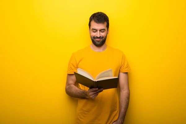 Uomo Sul Colore Giallo Vibrante Isolato Che Tiene Libro Diverte — Foto Stock