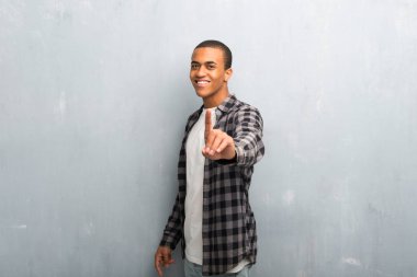 Afro-Amerikan delikanlı ile gösterilen ve parmak kaldırma kareli gömlek