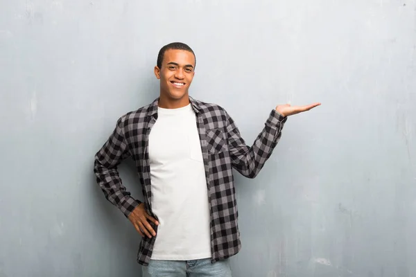年轻的非洲裔美国男子与格子衬衫持有复制空间想象的手掌插入广告 — 图库照片
