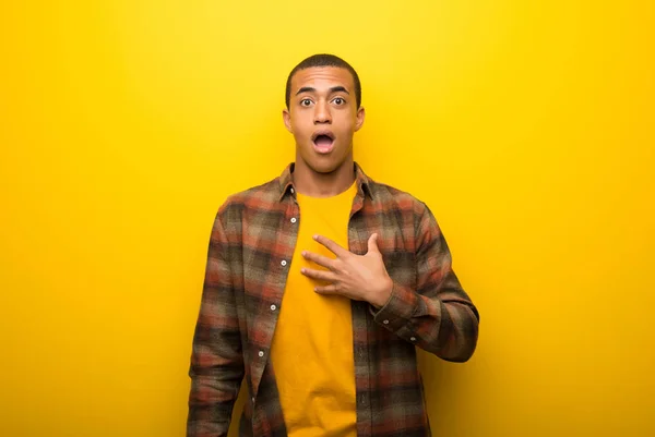 Junger Afrikanisch Amerikanischer Mann Auf Leuchtend Gelbem Hintergrund Überrascht Und — Stockfoto