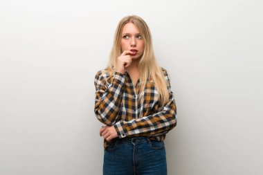 Sarışın genç kız beyaz duvar ararken şüpheleri üzerinde