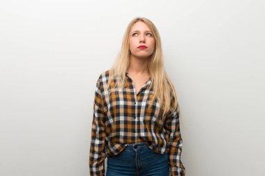 Beyaz duvar ile ciddi bir yüz ararken sarışın genç kız