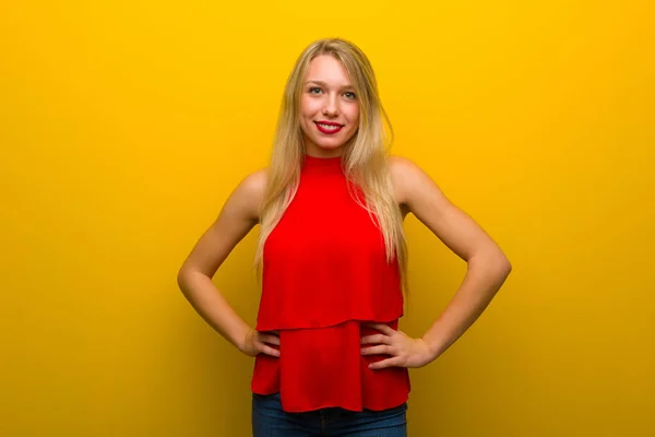 Młoda Dziewczyna Czerwoną Sukienkę Żółty Ścianę Pozowanie Ramion Biodra Śmiejąc — Zdjęcie stockowe