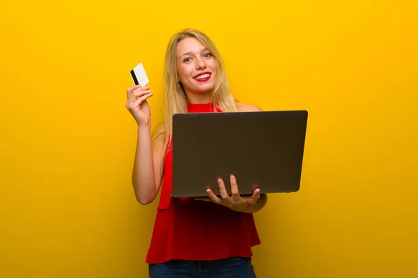 Jong Meisje Met Rode Jurk Gele Muur Met Laptop Creditcard — Stockfoto