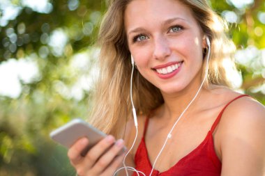 Genç sarışın kız kulaklık ile müzik dinlemek