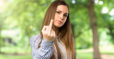 Açık havada, çizgili gömlek yapma boynuz hareketi ile genç kız