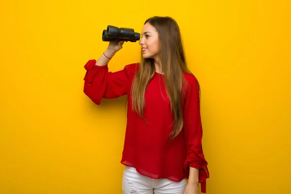 Mladá Dívka Červenými Šaty Žluté Zdi Dálce Při Pohledu Dalekohledem — Stock fotografie