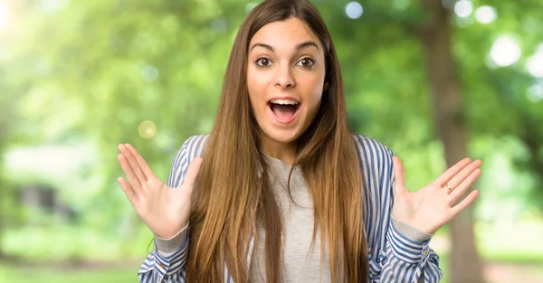 Junges Mädchen Mit Gestreiftem Hemd Mit Überraschung Und Schockiertem Gesichtsausdruck — Stockfoto
