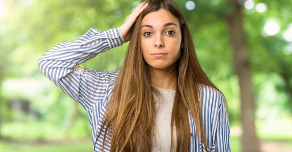 Young girl with striped shirt with an expression of frustration and not understanding at outdoors