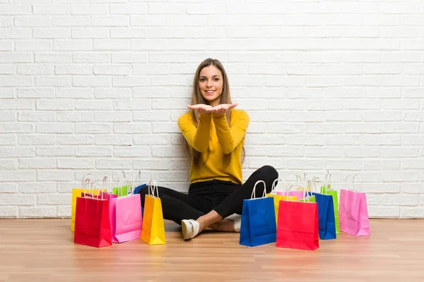 ショッピング袋を手のひらに架空の Copyspace を持っての多くの広告を挿入する少女 — ストック写真