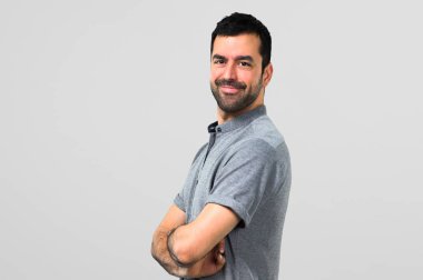 Silah tutmak yakışıklı adam gri arka plan üzerinde çarpı işareti