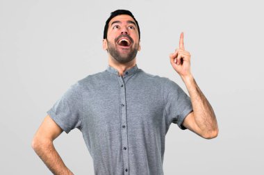 Ayakta ve gri arka plan üzerinde bir fikir düşünce yakışıklı adam