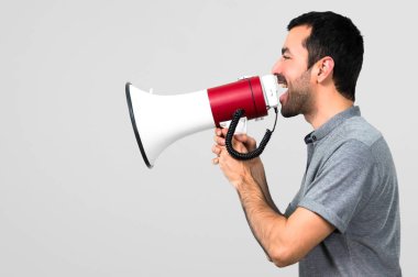 Yakışıklı adam bir megafon gri arka plan üzerinde tutan