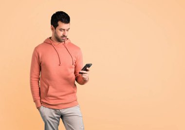 Pembe bir kazak bir mesaj veya e-posta ile belgili tanımlık hareket eden koyu sarı zemin üzerine gönderme erkekte