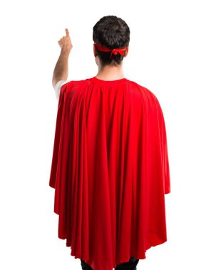 Süper kahraman maske ve kırmızı pelerin geri izole beyaz zemin üzerine işaret parmağı ile işaret eden adamla