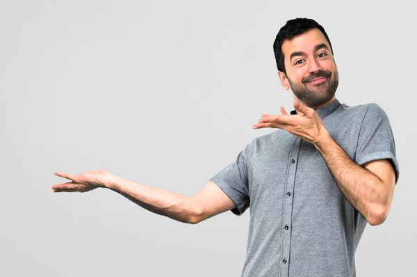 Hombre Guapo Presentando Algo Sobre Fondo Gris — Foto de Stock