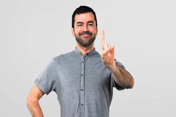 Hombre Guapo Contando Uno Sobre Fondo Gris —  Fotos de Stock