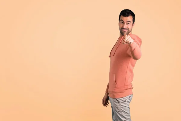 Man Pink Sweatshirt Points Finger You Confident Expression Ocher Background — Stock Photo, Image