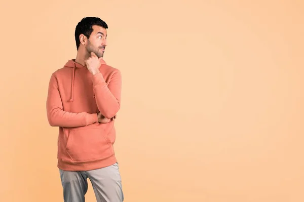 Man Pink Sweatshirt Standing Looking Side Ocher Background — Stock Photo, Image