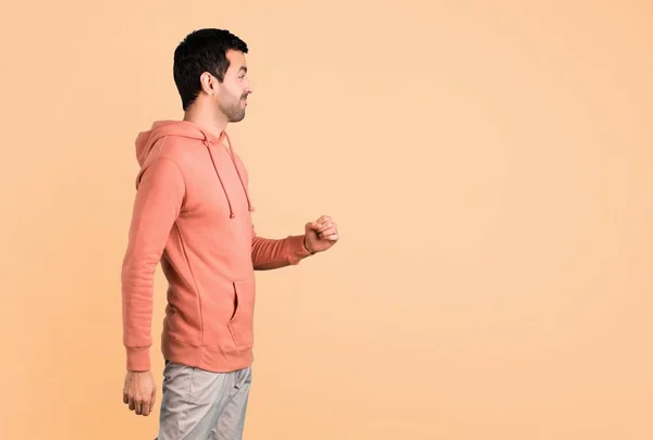 Man Pink Sweatshirt Walking Motion Gesture Ocher Background — Stock Photo, Image