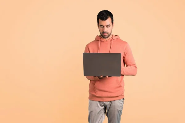 Hombre Una Sudadera Rosa Con Portátil Sobre Fondo Ocre — Foto de Stock