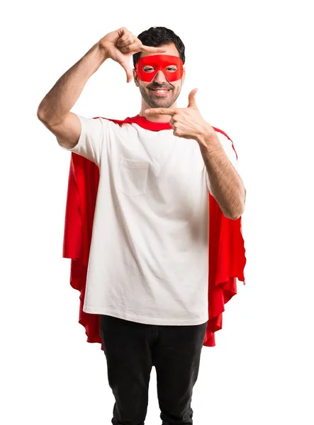スーパー ヒーロー マスクと赤のケープを中心に顔の男 分離の白い背景の上のシンボルをフレーミング — ストック写真