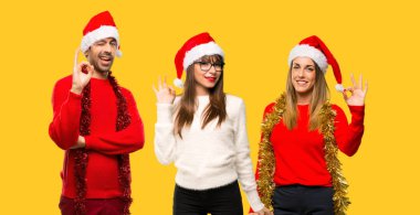 Bir ok işareti ile parmak sarı arka plan üzerinde gösterilen Noel tatili için bir grup insanlar sarışın kadın giyinmiş