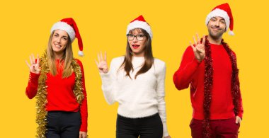 Mutlu Noel tatili için giyinmiş geri sayıma dört sarı zemin üzerine parmağınızla insanlar sarışın kadın bir grup